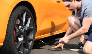 Person using a scissor jack to lift a car